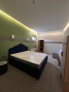塔什干Hamsa Butique Hotel Tashkent的一间卧室设有一张床和绿色的墙壁