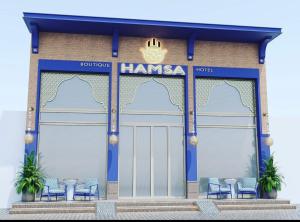 塔什干Hamsa Butique Hotel Tashkent的前面的商店,前面有蓝色的椅子