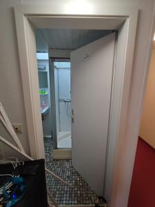 福尔巴赫Room in Guest room - Single room with shared bathroom and kitchen in Forbach的带淋浴的浴室和白色门