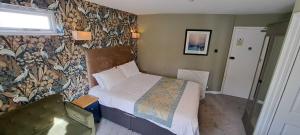 利明顿温泉Victoria Park Lodge & Serviced Apartments的一间小卧室,配有一张床和一面墙
