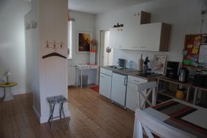 MüchelnFerienwohnung Maurer的厨房铺有木地板,配有白色橱柜。