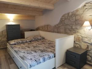 卡洛福泰A cà da Chidedda - IUN Q6445的一间卧室设有一张床和石墙