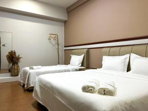 马六甲Mana Mana Hotel • Melaka •的酒店客房,配有两张带毛巾的床