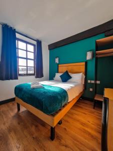 赫尔玉米磨坊酒店的一间卧室设有一张大床和绿色的墙壁