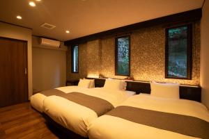 宫岛菊野屋酒店的配有窗户的客房内的两张床