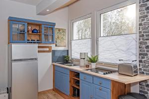 于克里茨Albatros - a17722的厨房配有蓝色橱柜和白色冰箱