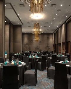卡兰古特Hyatt Centric Candolim Goa的宴会厅配有桌椅和吊灯。