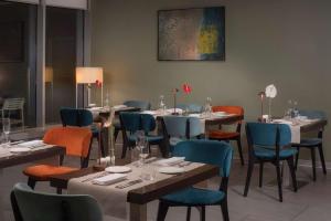 奥里奥阿塞里奥NH欧瑞欧阿尔赛瑞欧酒店的餐厅设有桌椅,墙上挂有绘画作品