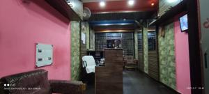 普里Hotel Samrat Palace Puri Near Sea Beach Excellent Service的一间设有粉红色墙壁和椅子的房间和一间酒吧