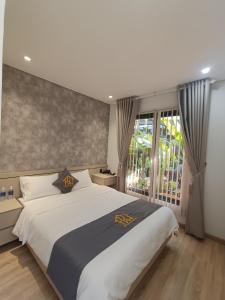 Buôn EnaoKim Đồng homestay的一间卧室设有一张大床和一个窗户。