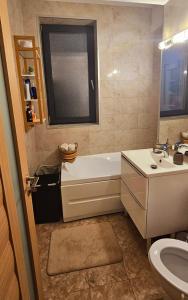 马马亚Iaki Apartment Mamaia的带浴缸、盥洗盆和卫生间的浴室