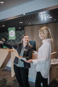 吕贝克Holiday Inn Lübeck, an IHG Hotel的两名妇女站在柜台前