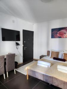 普里什蒂纳Hotel City Rooms Prishtina的一间卧室配有一张床、一张桌子和一台电视。