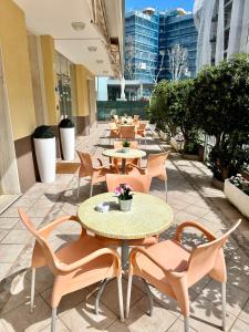 里米尼Hotel Enna Rimini的庭院里一排桌椅