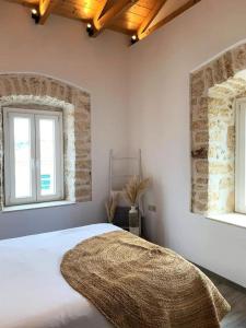 梅加尼西岛Mangata suites homes with private pools的卧室配有白色的床和2扇窗户。