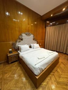 开罗CASTELLO HOTEL的一间卧室设有一张带木墙的大床