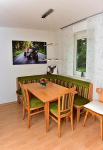 伦茨基希Appartement in Saig mit Garten und Grill的一间带木桌和椅子的用餐室