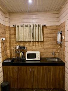 罗纳瓦拉Imagine Harmony的厨房配有带微波炉和水槽的台面