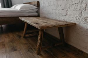 卡缅涅茨-波多利斯基Hotel Dynasty的一张木桌,位于带一张床的房间里