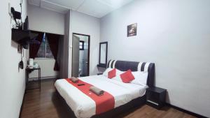 丹那拉打Hotel Rasa Sayang 2的一间卧室配有一张带红色枕头的大床