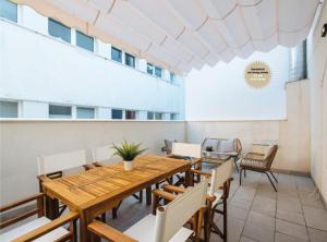 塞维利亚Magno Apartments San Martín Terrace的一间带木桌和椅子的用餐室