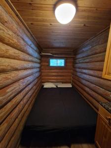 米凯利Kuikkoniemi- A Lake view cabin with hot tub n more的小木屋内的小房间,配有一张床