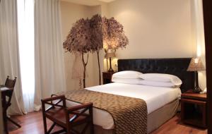 里瓦德塞利亚乌格尼娅花园酒店的一间卧室配有一张大床和黑色床头板