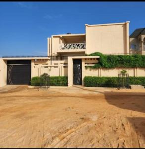 尼亚美Kalinou Niamey的大型白色房屋,设有大型车道