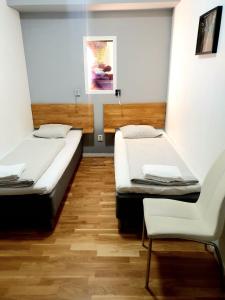 斯德哥尔摩莫斯贝克旅馆的一间设有两张床和椅子的房间
