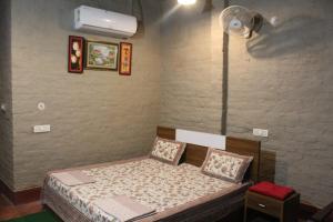 KālādhūngiWoodpecker Homestay的一间带一张床和风扇的小卧室