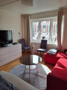 克里斯蒂安桑Apartment Bystranda - City Beach的客厅配有红色沙发和茶几