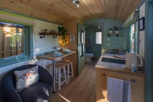 StittenhamCosy Shepherds Hut with hot tub in the Scottish Highlands的一间小厨房和一间位于小房子内的客厅