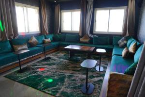 阿加迪尔Great Holiday Apart-Hotel & Penthouse的客厅配有绿色沙发和桌子