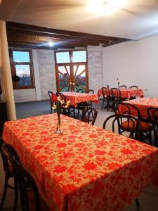 SkorenovacEdukativ Szállás的一间设有红色桌椅和窗户的用餐室
