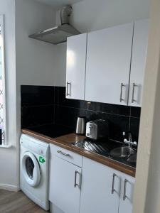 凯特林Stylish and Spacious Wi-Fi Smart TV Tea and coffee的厨房配有水槽和洗衣机