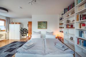 农嫩霍恩Exklusives Josenhaus mit See- und Alpenblick & Gartensauna的一间卧室配有一张带书架的大床