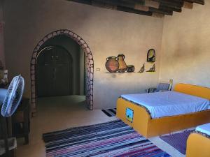 ‘Ezbet HalfaQasr El Bagawat Hotel的一间卧室设有一张床和一个拱形门廊