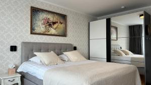 沃鲁Promenaadi Apartment的一间卧室设有两张床,墙上挂着一幅画