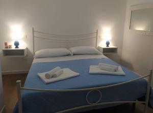 米拉佐Dimora d'Estate (Sicilian Holidays)的一间卧室配有一张床、两条毛巾和两盏灯。