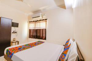 海得拉巴FabHotel Opal Residency的一间卧室设有一张床和一个窗口