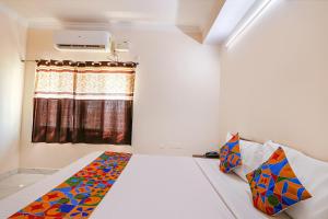 海得拉巴FabHotel Opal Residency的一间卧室配有床和带窗帘的窗户
