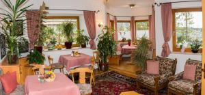 蒂罗尔-泽费尔德KREUZHOF Seefeld的一间设有桌椅的餐厅,种植了植物