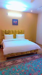 伊斯兰堡Pearl Executive Villa Islamabad的一间卧室配有一张大床和木制床头板