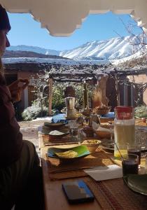 TimitAlliance Berbère - Vallée d'Aït Bouguemez的一张桌子,上面有食物,后面有山