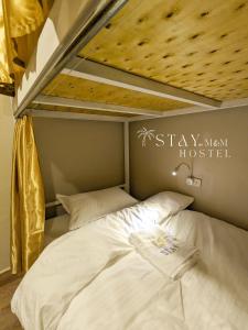 他曲STAY Hostel & Motorbike Rental - Thakhek的现代旅馆标志牌的宿舍间内的一张床位