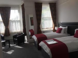 克罗伊登Croham Park B&B - Free Parking & Wi-Fi的酒店客房,配有两张床和椅子