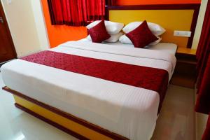 蒙纳Angel Holidays的一间卧室配有一张带红色和白色枕头的大床