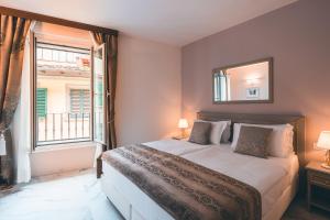 佛罗伦萨帕拉索本齐酒店的一间卧室设有一张大床和一个窗户。