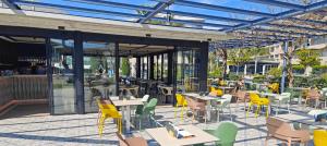 圣苏珊娜AQUA Hotel Onabrava & Spa 4*Sup的室外餐厅设有桌椅和窗户。