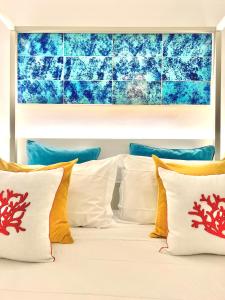 卡普里Suite Apartment Capri con Jacuzzi in Piazzetta的一张带白色枕头和蓝色墙壁的床